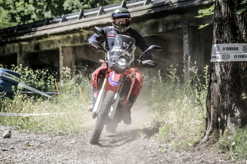 Enduro rossa nella polvere sotto la struttura della sopraelevata