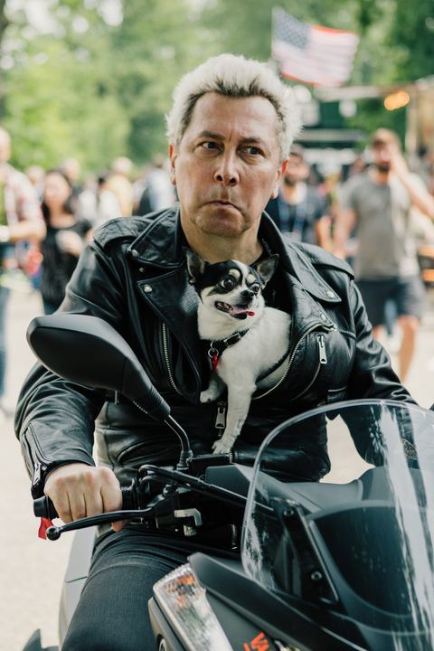 Motociclista col cagnolino nel giubbotto