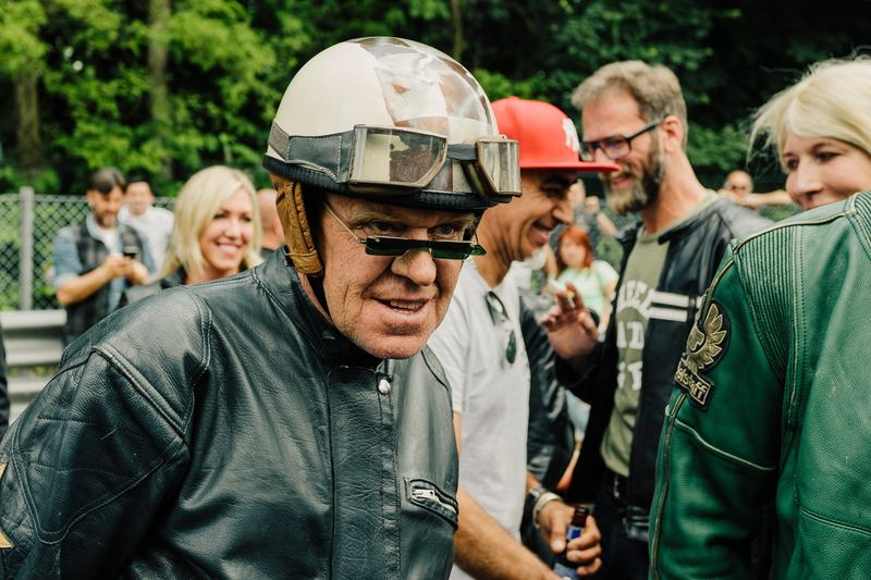 Pilota anziano col casco aperto che ride